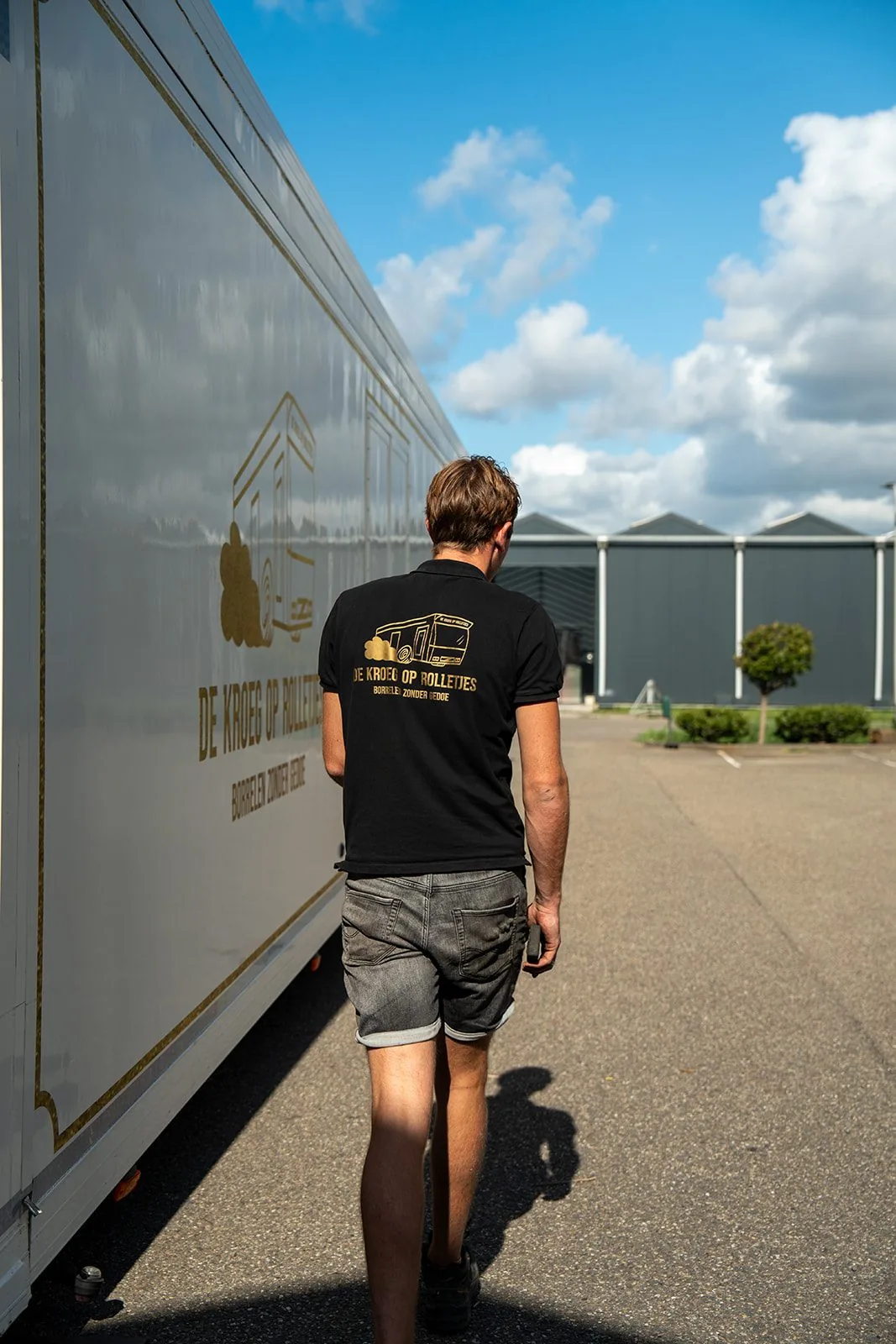 Op weg langs De Kroeg XL, in poloshirt met het logo op de rug.