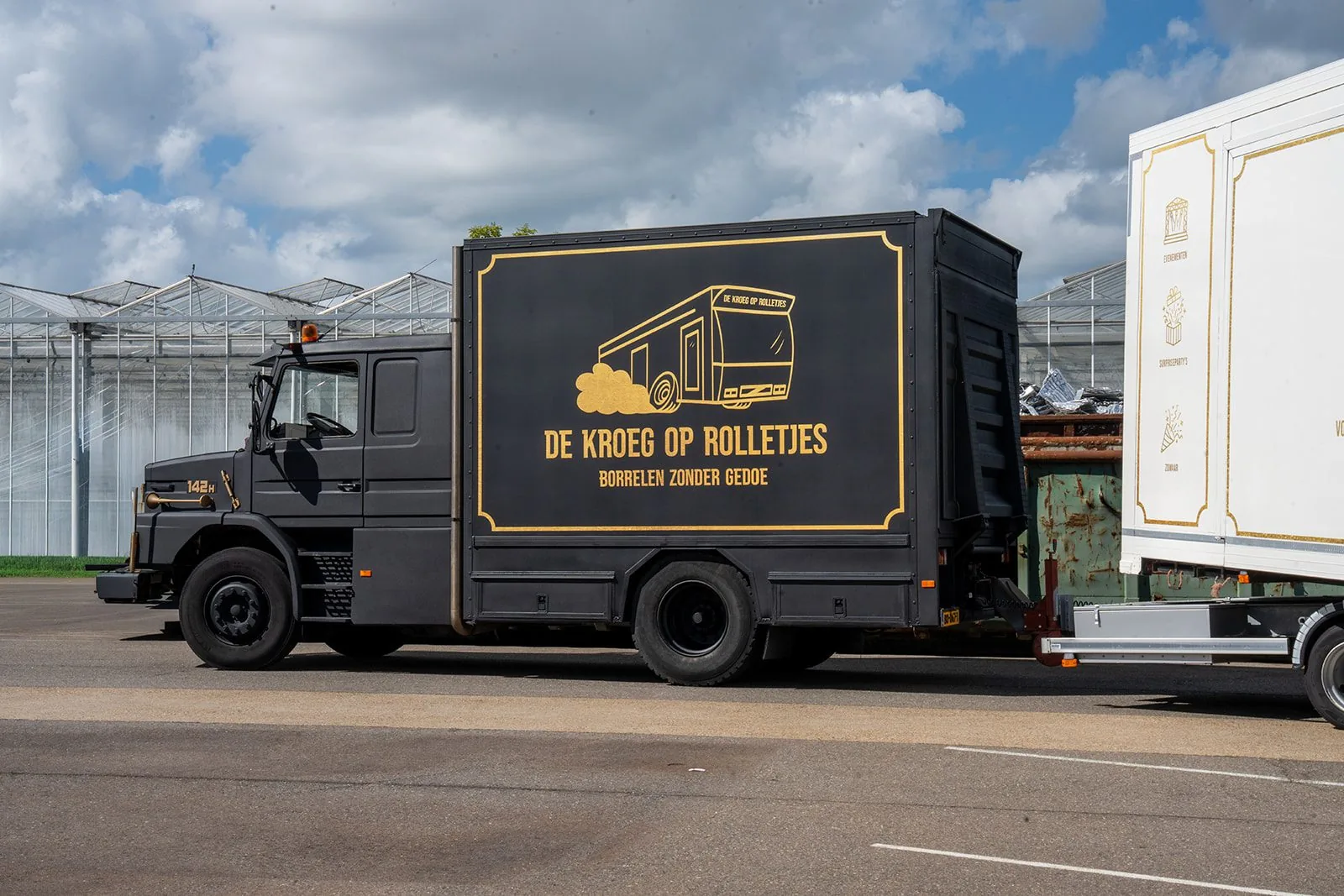 De zwarte vrachtwagen met gouden belettering die De Kroeg XL naar de locatie brengt.