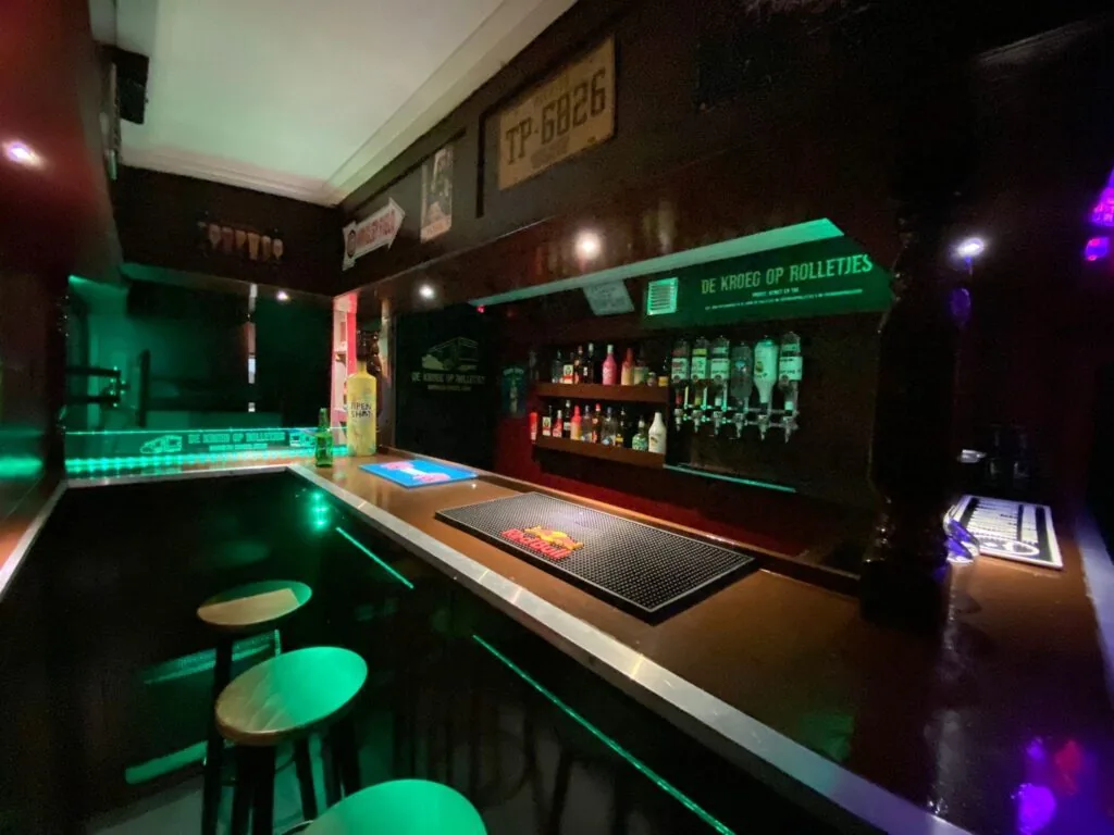 De bar in de kroeg met tapkranen en groene LED-verlichting.